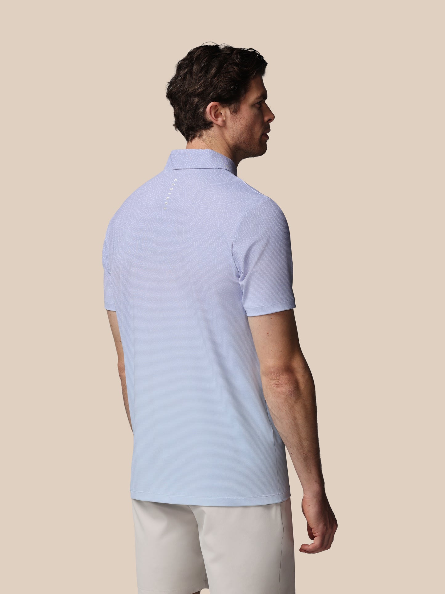 Man wearing a light blue polo shirt on a beige background