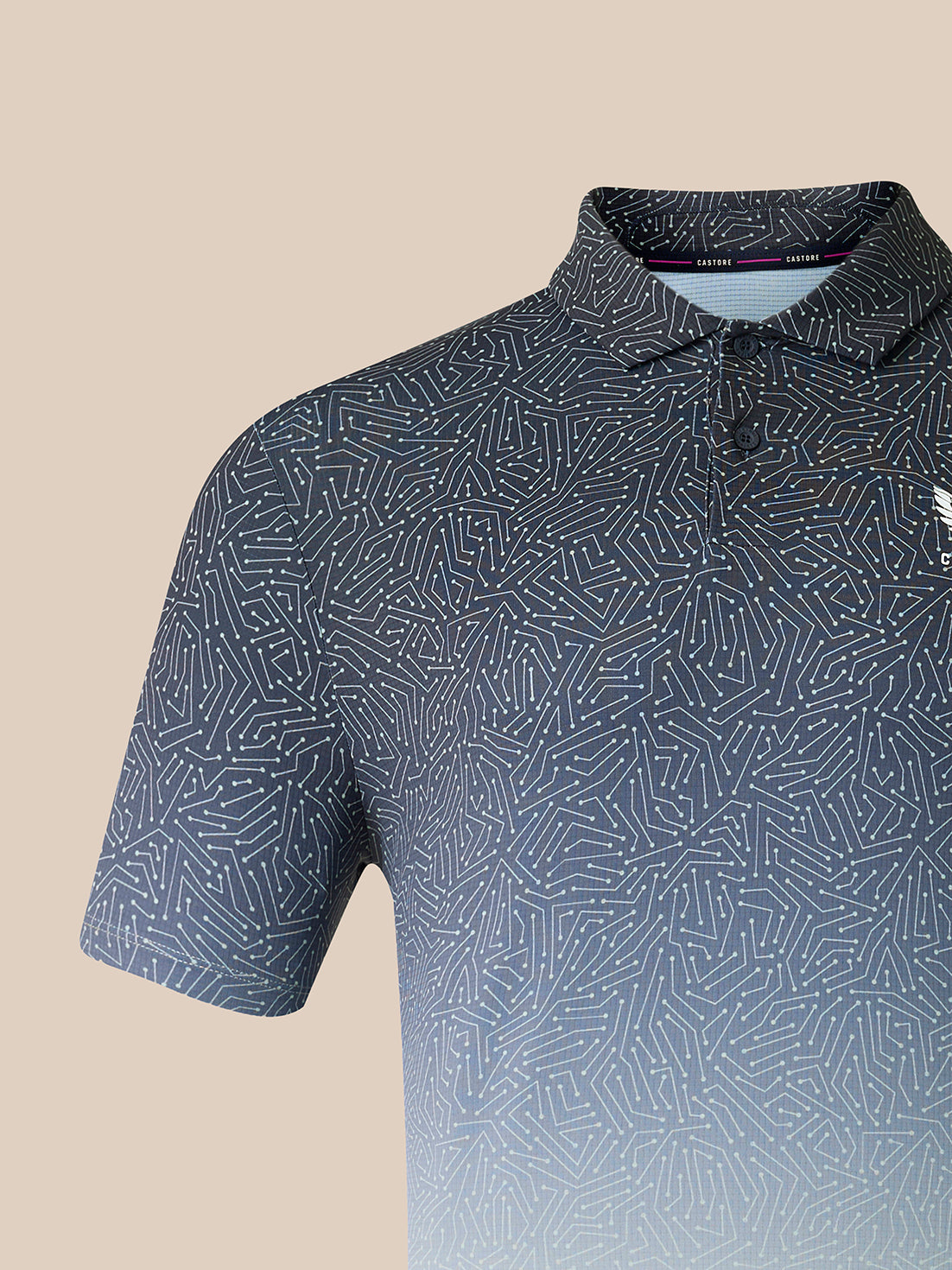 A close-up of a short-sleeve polo shirt with a geometric line pattern in navy blue and white, featuring a subtle gradient at the bottom and a small embroidered logo on the chest.