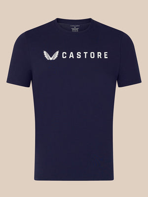 A navy blue short-sleeve crewneck t-shirt with a white Castore wing logo and brand name printed across the chest, displayed against a solid beige background.