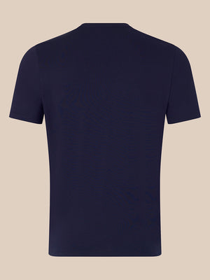 A plain navy blue short-sleeve crewneck t-shirt shown from the back, displayed on a solid light beige background.