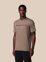 Man wearing a brown t-shirt with 'Castore' logo on a beige background