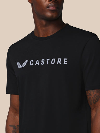 Person wearing a black t-shirt with 'CASTORE' logo on a beige background