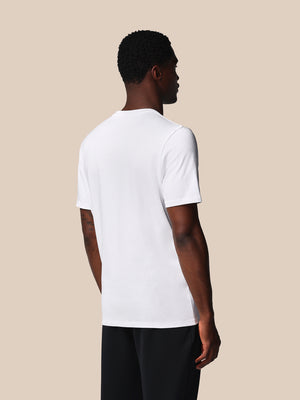 Person wearing a white t-shirt on a beige background