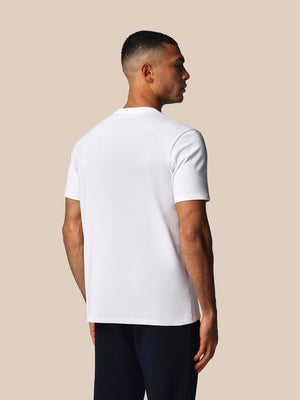 Man wearing a white t-shirt against a beige background