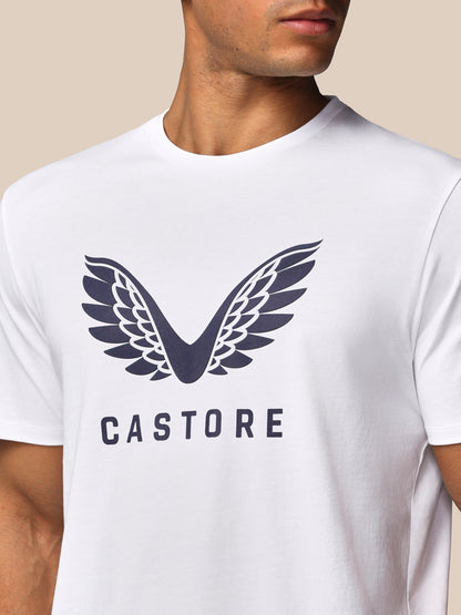 White t-shirt with a dark blue logo and 'CASTORE' text on a beige background