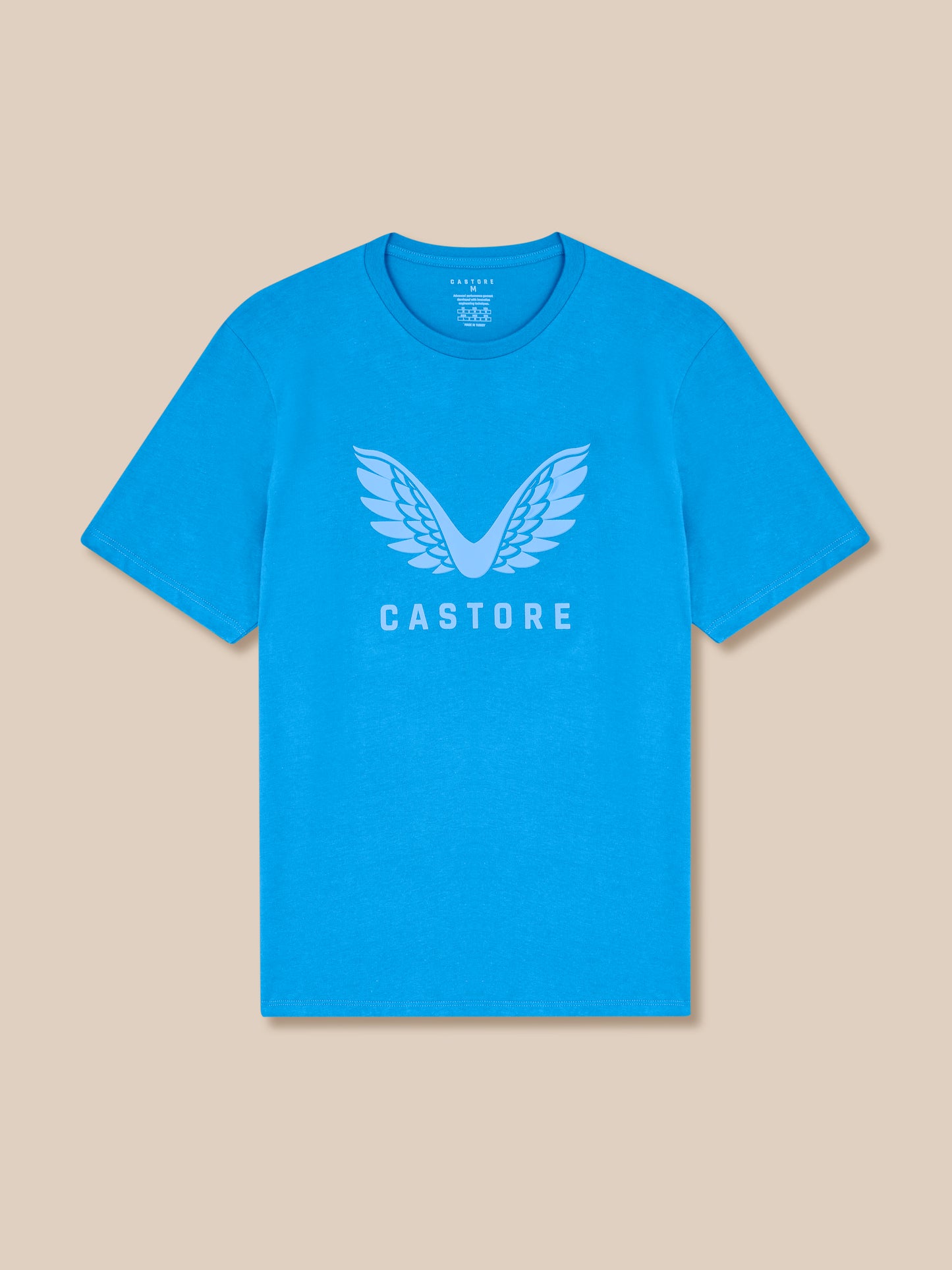 Blue t-shirt with 'Castore' logo on a beige background
