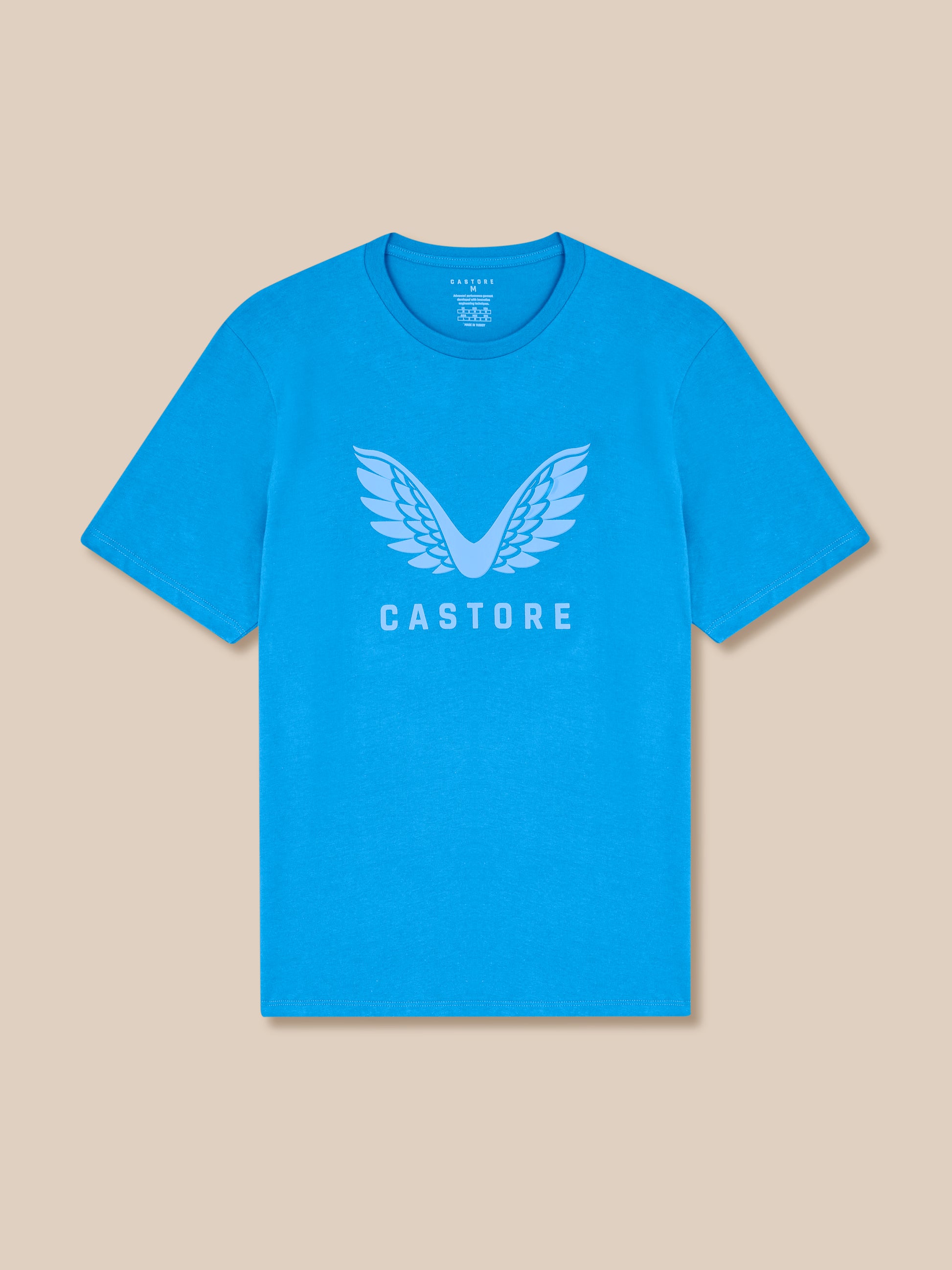Blue t-shirt with 'Castore' logo on a beige background