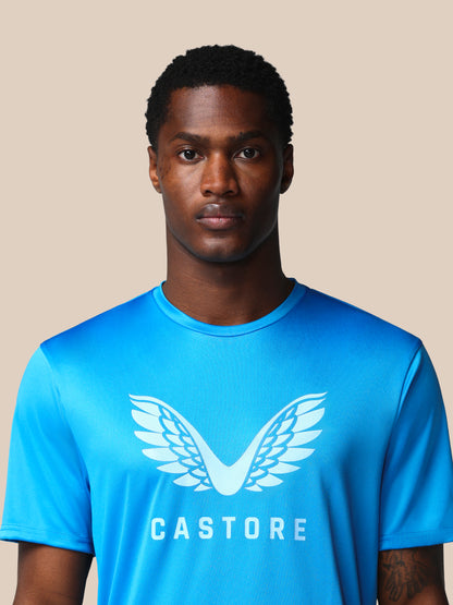 Man wearing a blue Castore t-shirt against a beige background