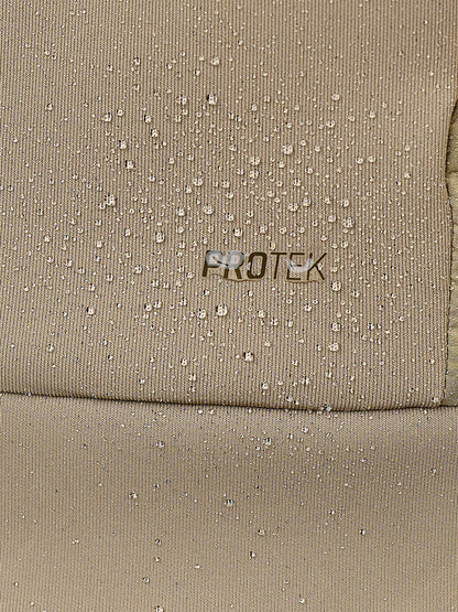 Close-up of a beige textured fabric with water droplets on the surface and the word PROTEK printed in the center.