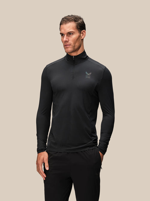 Male model wearing black long sleeve quarter zip top from Reiss x Castore front view