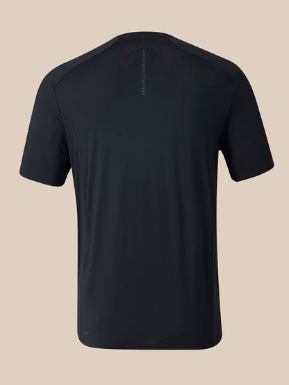 A black short-sleeve athletic t-shirt shown from the back, featuring a subtle vertical logo on the upper back and a small logo near the lower hem, set against a solid beige background.