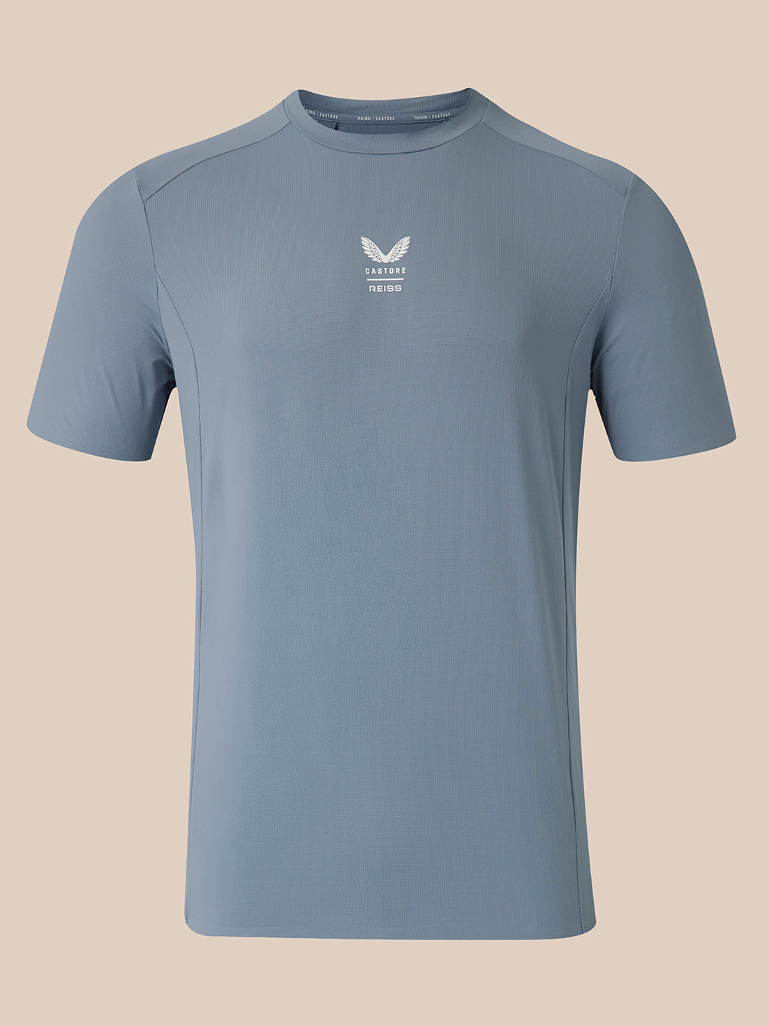 A light blue athletic short-sleeve t-shirt with a small white logo on the center chest, displayed on a solid beige background.