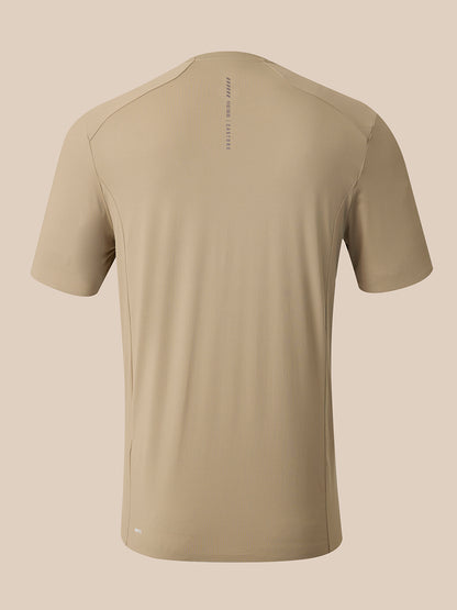 A short-sleeve athletic t-shirt in a light khaki-beige color, shown from the back on a solid beige background. The shirt features a subtle vertical text print on the upper back reading 'REISS CASTORE.