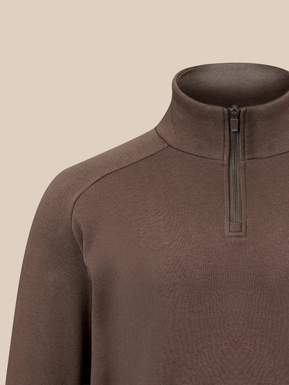 Close-up of a brown quarter-zip mock neck sweater on a mannequin against a solid beige background.