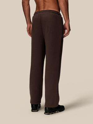 Back view of brown wide leg fleece joggers on a model, showing the elastic waistband and relaxed fit