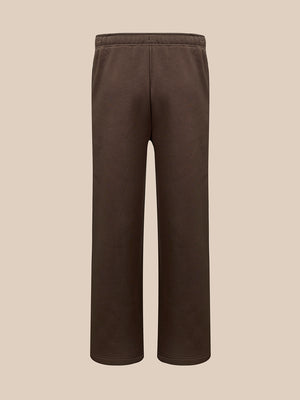 A pair of dark brown sweatpants with a drawstring waist , shown against a solid beige background.