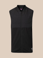A black sleeveless zip-up vest with a mock neck and horizontal quilting, shown against a solid beige background. A small white logo is visible on the bottom right hem.