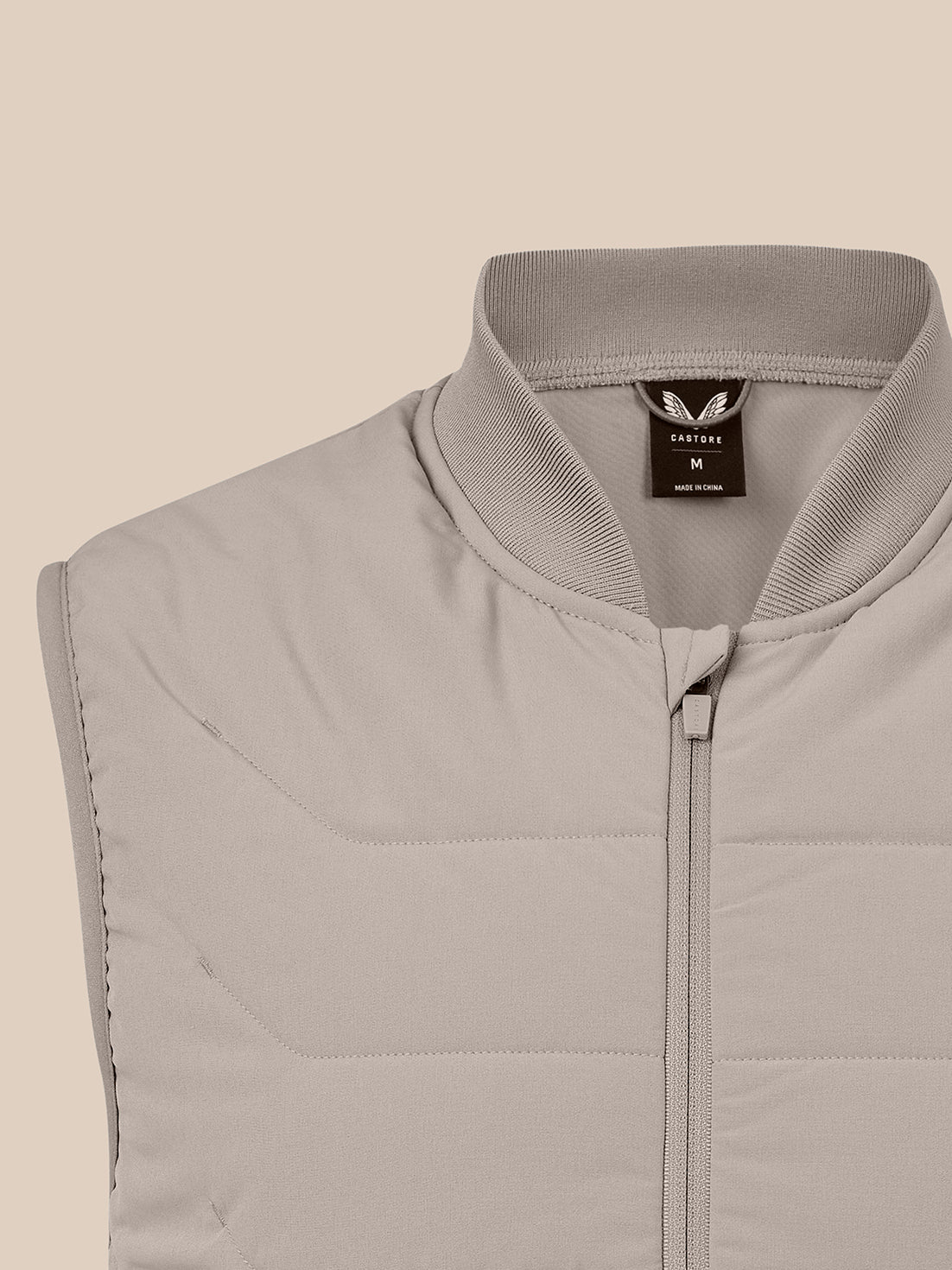 Close-up of taupe men's thermo hybrid gilet showing ribbed stand collar, quilted upper chest and front zipper