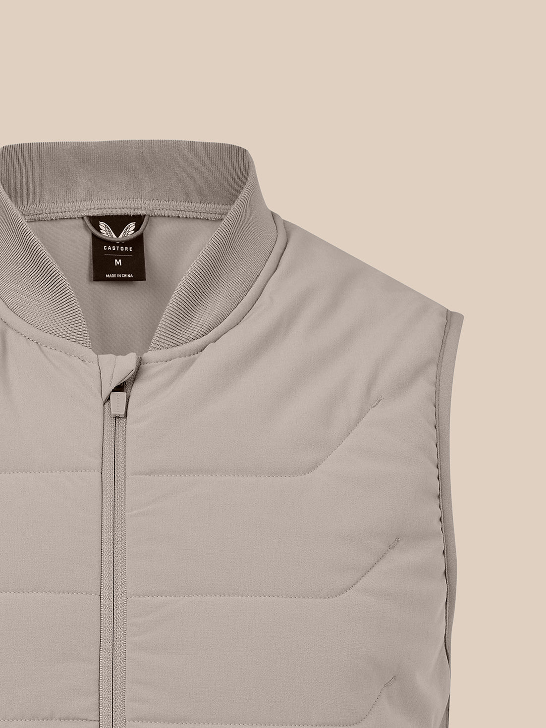 Close-up view of taupe thermo hybrid gilet neck area with quilted chest panel and visible neck label