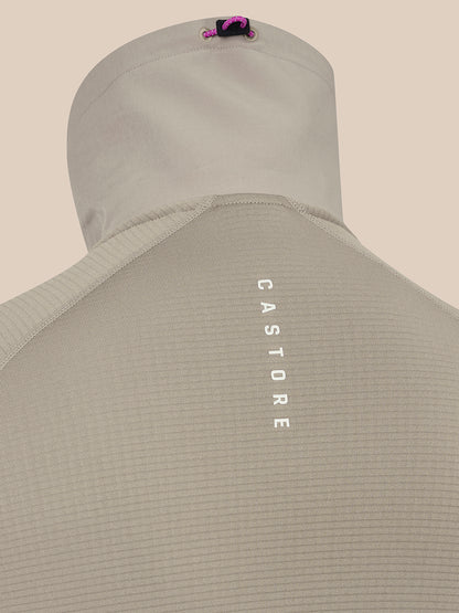 Close-up of the back of a light beige hooded top on a mannequin, showing vertical white 'CASTORE' text on the back and a small pink and black logo near the hood.
