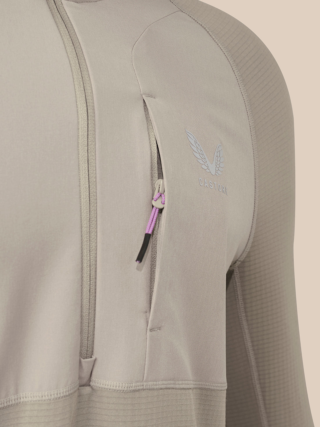 Close-up of a taupe men's slim fit thermo top showing a chest zipper and Castore logo