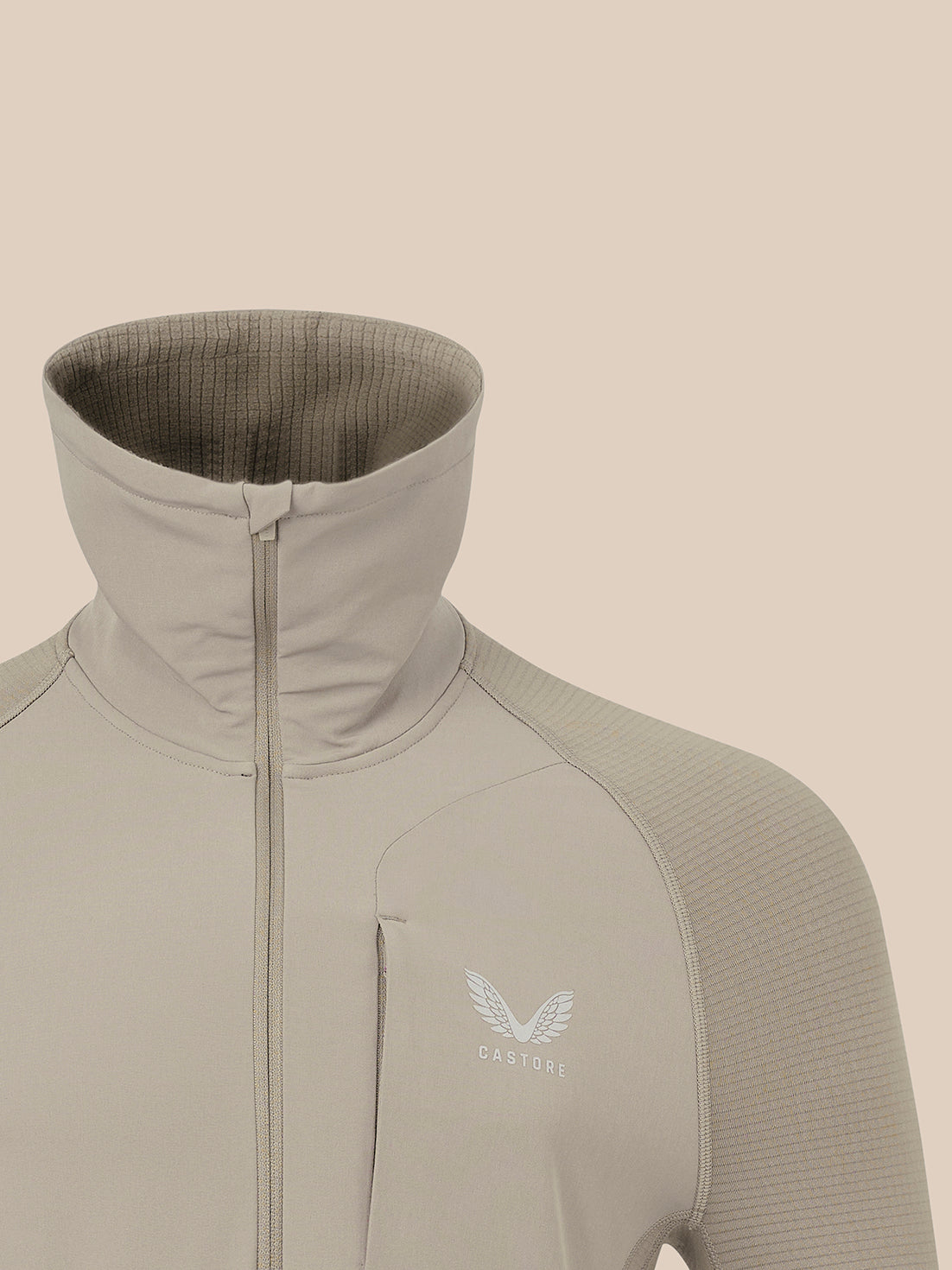 Taupe zip-front thermal jacket with funnel neck and raglan sleeves, Castore logo on chest.