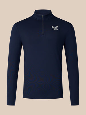 A navy blue long-sleeve quarter-zip pullover with a small white winged logo and the word 'CASTORE' on the left chest, displayed against a solid beige background.