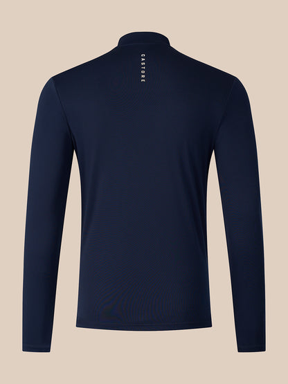 A navy blue long-sleeve quarter-zip pullover shown from the back, featuring a small vertical white 'CASTORE' logo printed on the upper back, set against a solid beige background.