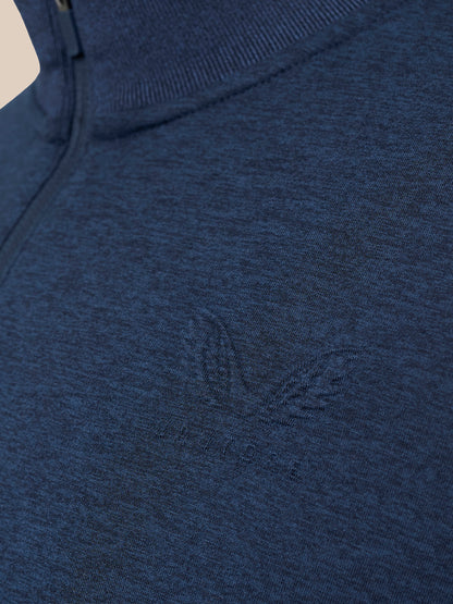 Close-up of a dark heather blue knit top with a subtle tonal embroidered logo on the chest.