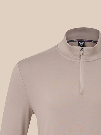 Close-up of a long-sleeve quarter-zip pullover in a light taupe-beige color, featuring a mock neck collar and a small black brand tag inside the collar.