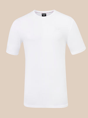 A white short-sleeve crewneck t-shirt with a small tonal embroidered logo on the left chest, displayed on a solid beige background.