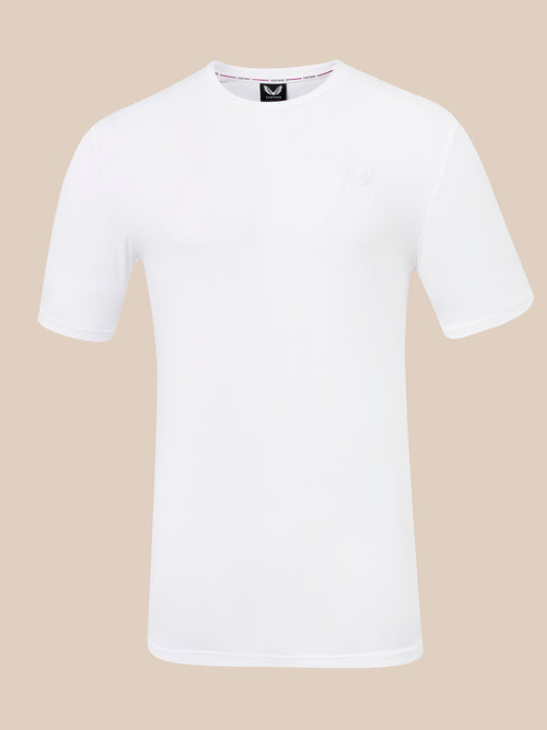 A white short-sleeve crewneck t-shirt with a small tonal embroidered logo on the left chest, displayed on a solid beige background.