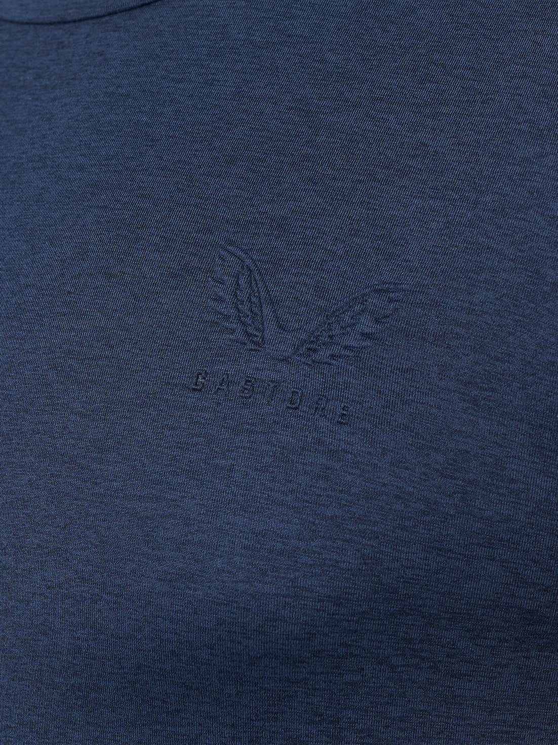 Close-up of a dark navy blue heathered fabric with a tonal embossed winged logo and the word 'CASTORE' centered on the chest.