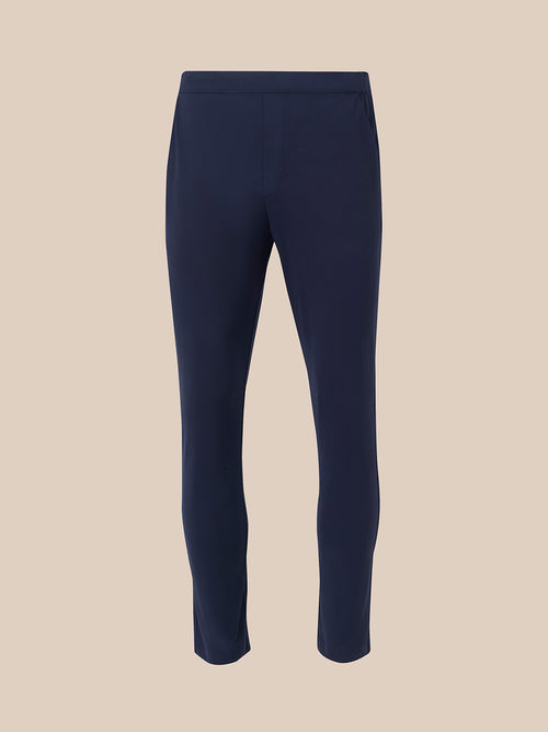 Back view of navy elevated lifestyle slim fit trousers with partially elasticated waistband and pink zip pull on rear pocket