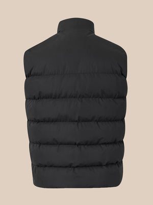 A black sleeveless puffer vest shown from the back, featuring horizontal quilting and a high collar, set against a solid beige background.