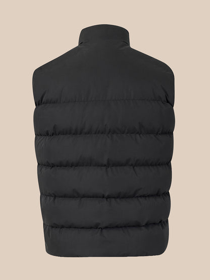 A black sleeveless puffer vest shown from the back, featuring horizontal quilting and a high collar, set against a solid beige background.