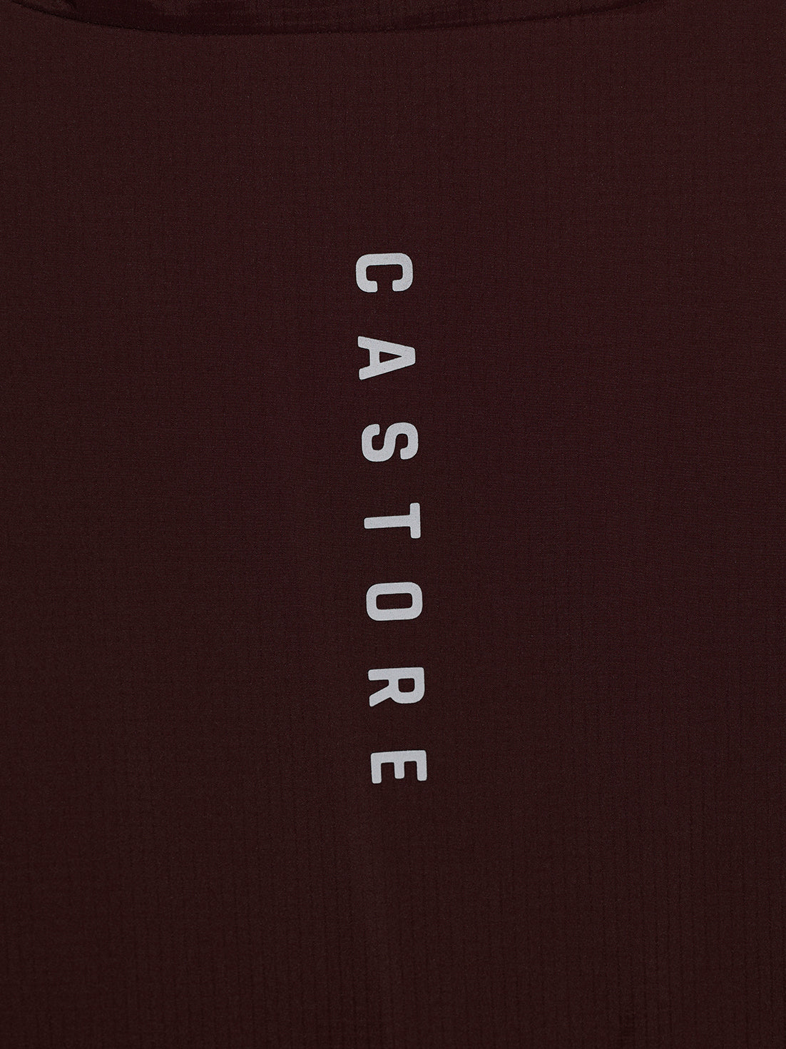 Close-up of a dark brown ribbed fabric with the word 'CASTORE' printed vertically in white capital letters.