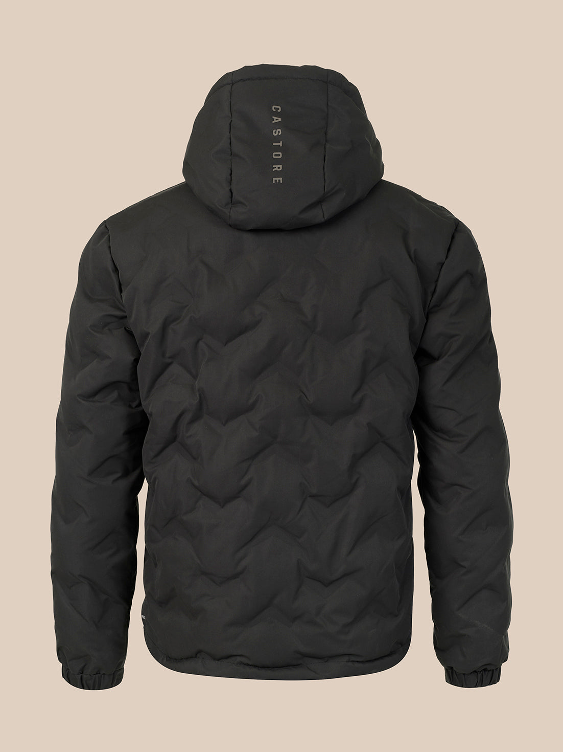 A black quilted hooded jacket shown from the back, featuring a vertical 'CASTORE' logo printed on the back of the hood, set against a solid beige background.