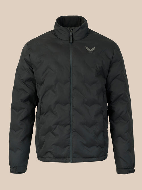A black quilted zip-up jacket with a stand-up collar and a subtle gray wing logo on the left chest, displayed against a solid beige background.