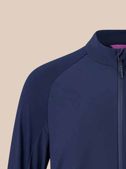 Close-up of a navy blue athletic zip-up jacket with a mock neck collar, set against a solid beige background.