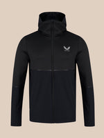 A black hooded zip-up jacket with a subtle horizontal seam across the lower torso, featuring a small white wing logo and the brand name 'CASTORE' on the left chest, displayed against a solid beige background.