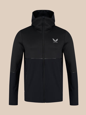 A black hooded zip-up jacket with a subtle horizontal seam across the lower torso, featuring a small white wing logo and the brand name 'CASTORE' on the left chest, displayed against a solid beige background.