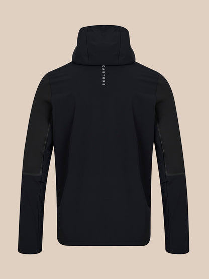 A black hooded jacket shown from the back, featuring a vertical white 'CASTORE' brand logo on the upper back, set against a solid beige background.