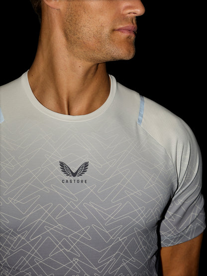 Close-up of a man wearing a Castore athletic t-shirt with a light gray and white geometric pattern, featuring the Castore wing logo on the chest.