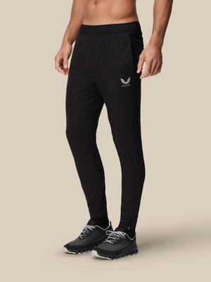 Men's black slim fit thermo woven joggers with Castore logo on the left thigh and athletic shoes