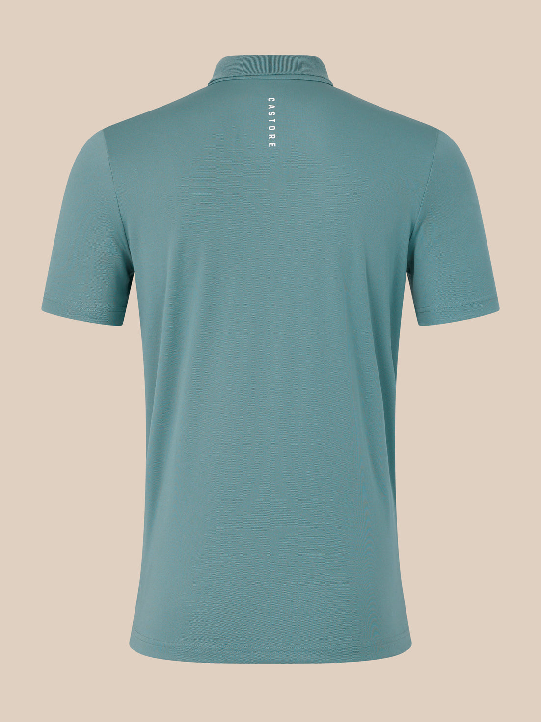 Teal polo shirt with 'Castore' branding on a beige background