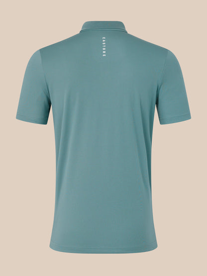 Teal polo shirt with 'Castore' branding on a beige background