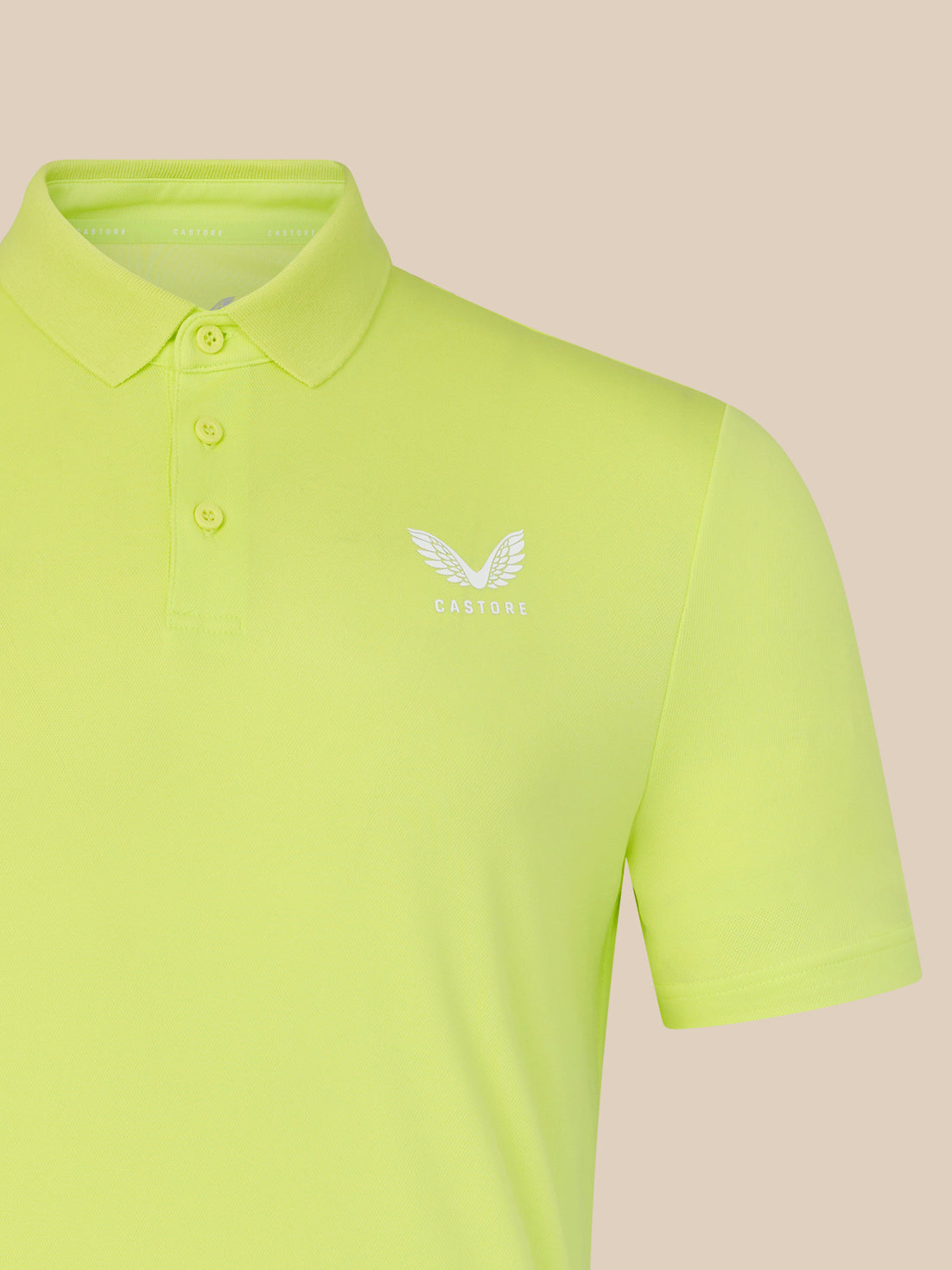 Light green polo shirt with a logo on a beige background