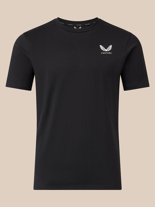 A black short-sleeve crewneck t-shirt with a small white winged logo and the word 'CASTORE' printed on the left chest, displayed against a solid beige background.