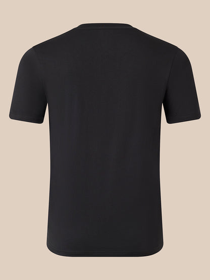 A plain black short-sleeve crewneck t-shirt shown from the back, displayed on a solid beige background.